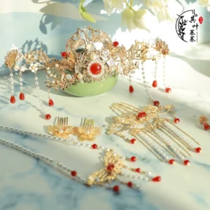 Complete red and gold Hanfu hair accessories set with Chinese bridal crown hair combs hairpins earrings pearls red gemstones and tassels displayed on a blue marble surface