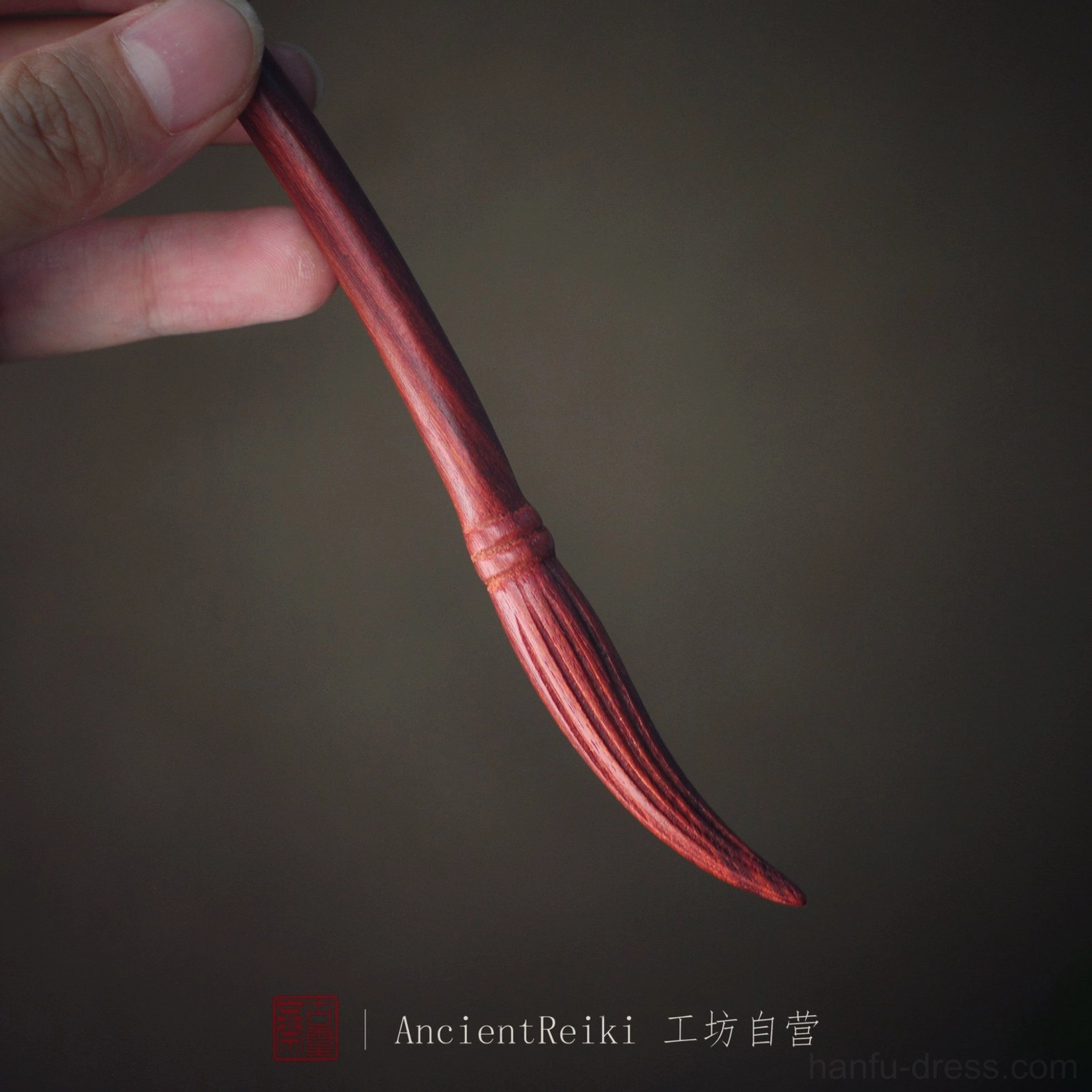 Red ink brush style Chinese hair stick held between fingers with realistic carved brush head for Hanfu bun styling