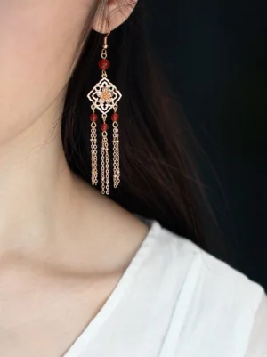 Close-up of red onyx tassel Hanfu earrings worn with a white linen traditional Chinese style top, showing the rhombus pendant and flowing tassels