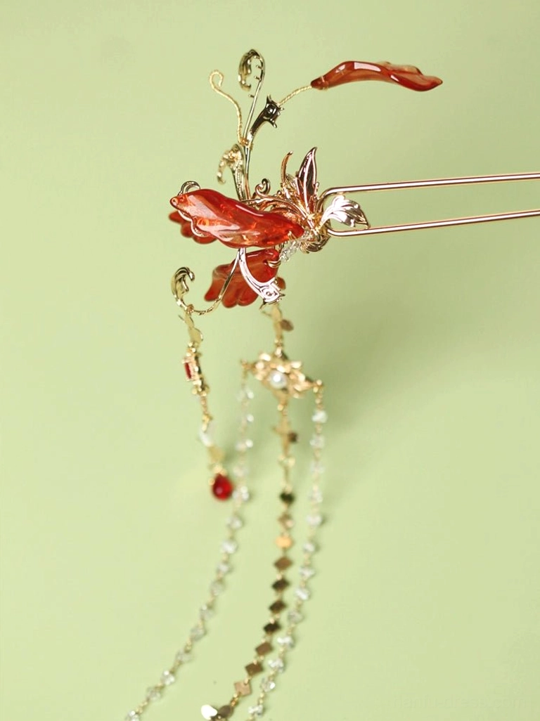 Front close-up of red spider lily Hanfu hair accessory with glossy red petals, gold-tone setting, clear crystal chain tassels, and red bead accent
