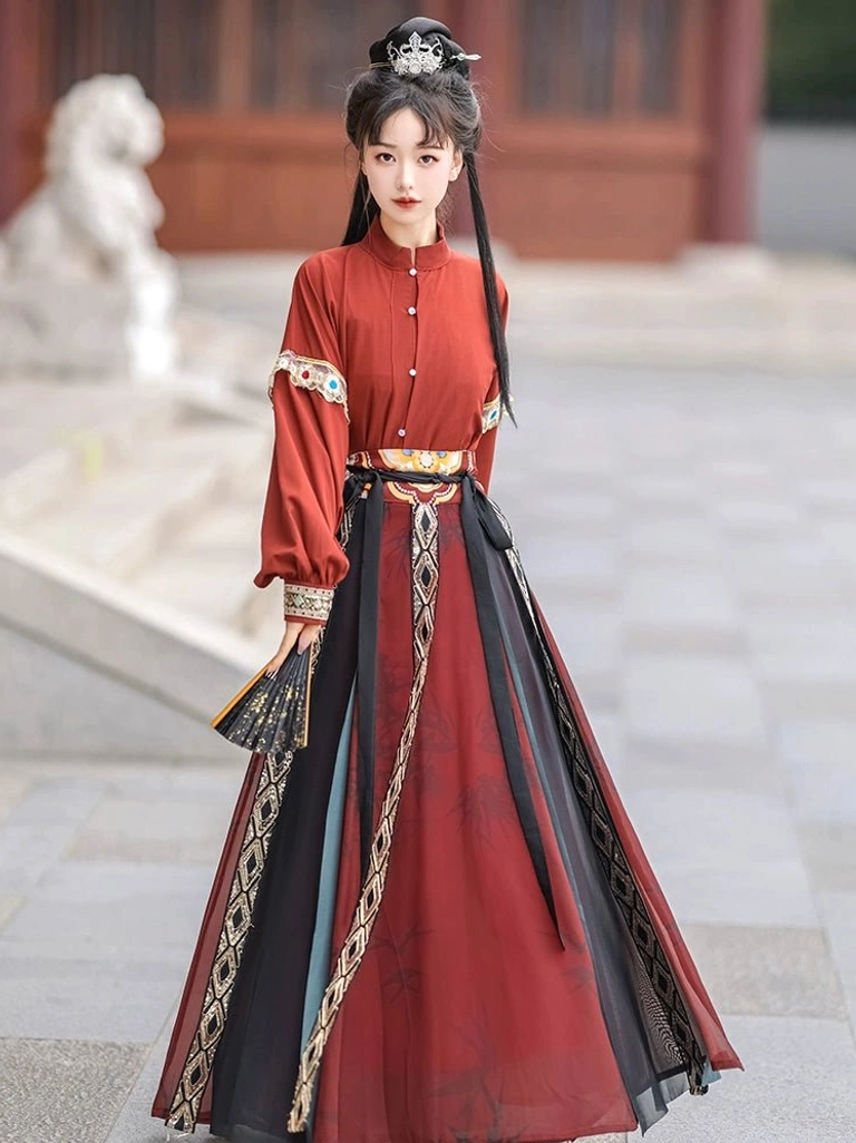 Red Tang Dynasty hanfu top with stand collar long sleeves and color-blocked high-waist wrap skirt with embroidered trim in a traditional courtyard