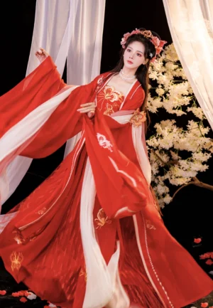 Three-quarter front view of a scarlet Tang Dynasty wedding hanfu dress with ornate gold bodice embroidery, flowing floor-length skirt, wide chiffon sleeves, and traditional bridal styling