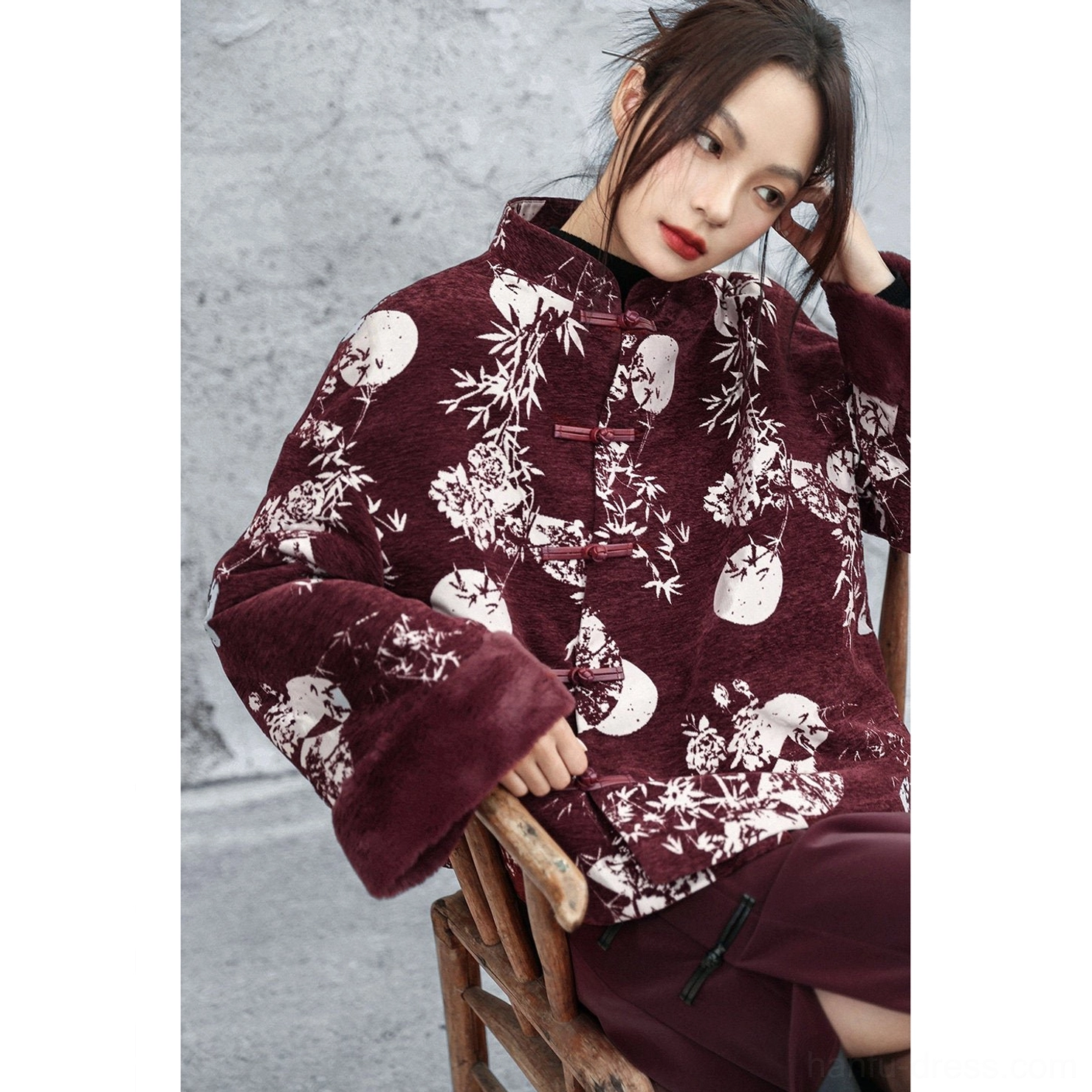Side view of a relaxed-fit burgundy Chinese-style Hanfu winter jacket with full bamboo moon floral print, stand collar, fuzzy cuffs, and matching wine-red styling