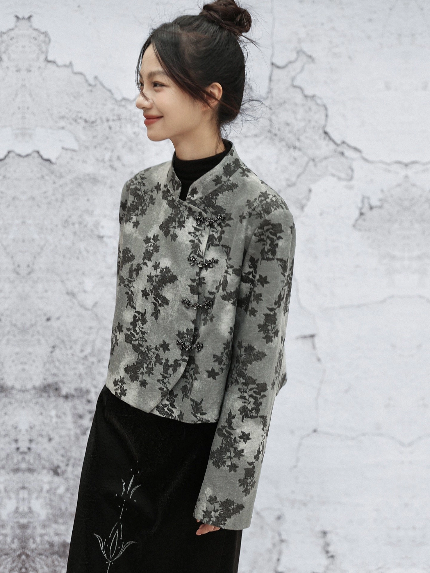 Side view of relaxed grey botanical print Modern Hanfu cropped jacket paired with a black embroidered long skirt