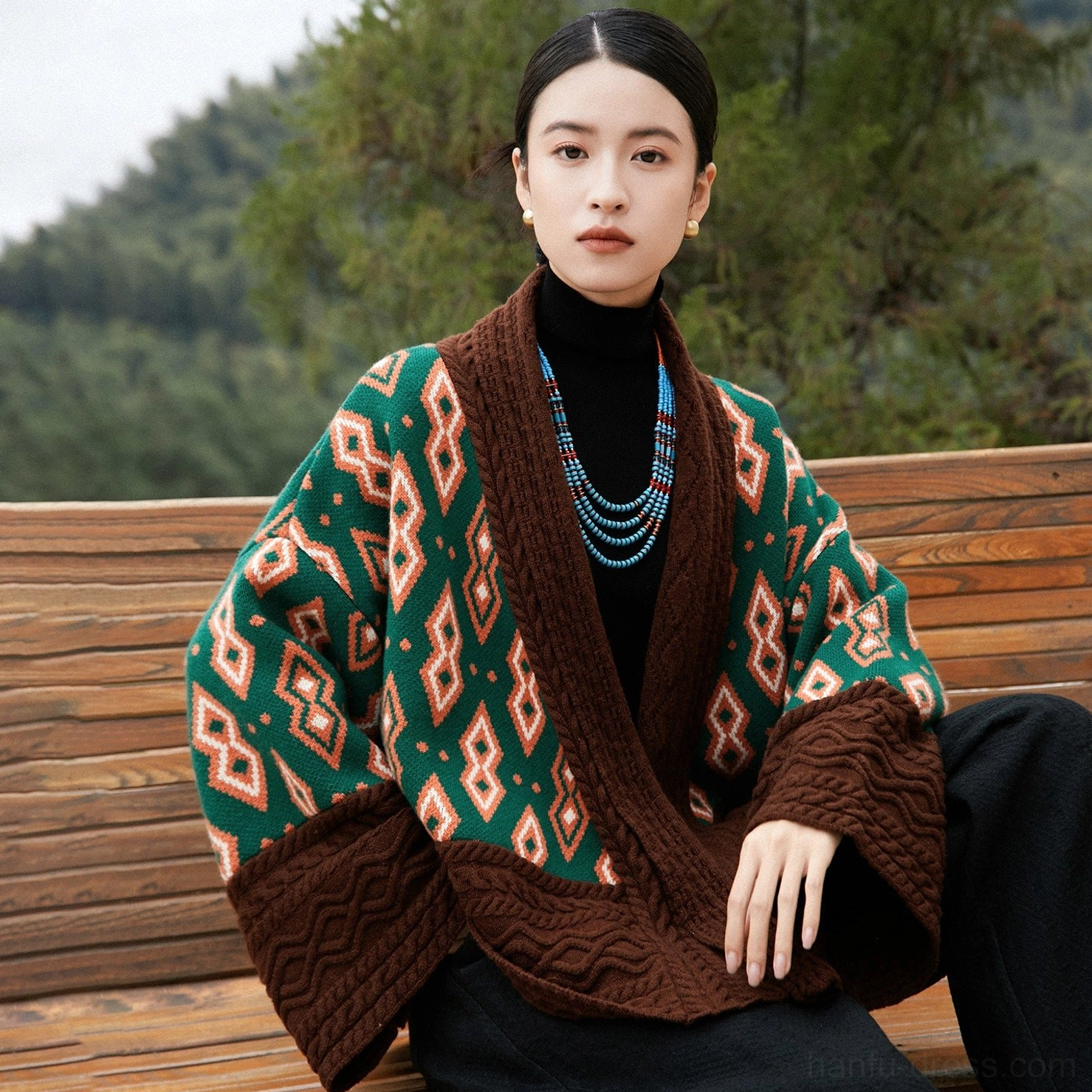 Relaxed oversized modern Hanfu wool knit cardigan jacket worn in a natural mountain setting with contrast green orange and brown colors