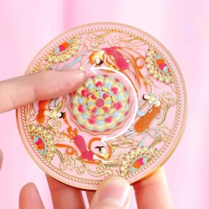 Rose pink Dunhuang flying apsaras Chinese pocket mirror held in hand showing the raised 3D lotus and celestial figure design