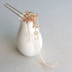 Close-up of Chinese style rose gold flower hair pin with dangling pearl-like tassels crystal drops and round cat-eye-style accent