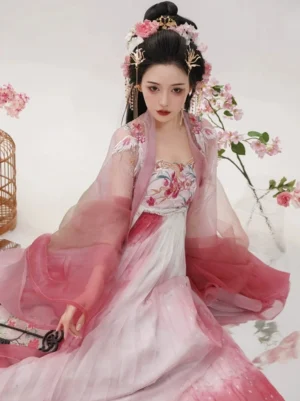 Seated portrait of a woman wearing a rose gradient Tang Dynasty Hanfu dress with embroidered floral bodice, flowing translucent outer coat, and elegant traditional hair accessories