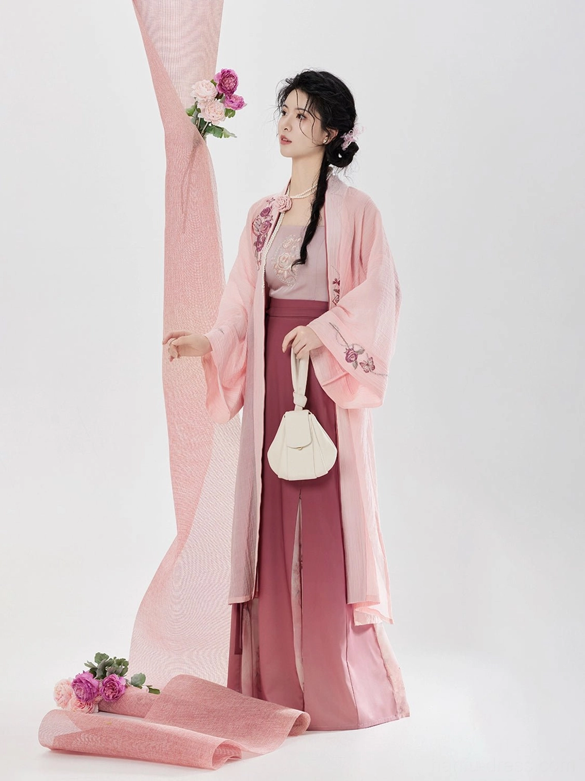 Song Dynasty inspired pink hanfu outfit shown from the side with floral embroidered beizi lapels cuffs and coordinated layered rose color skirt