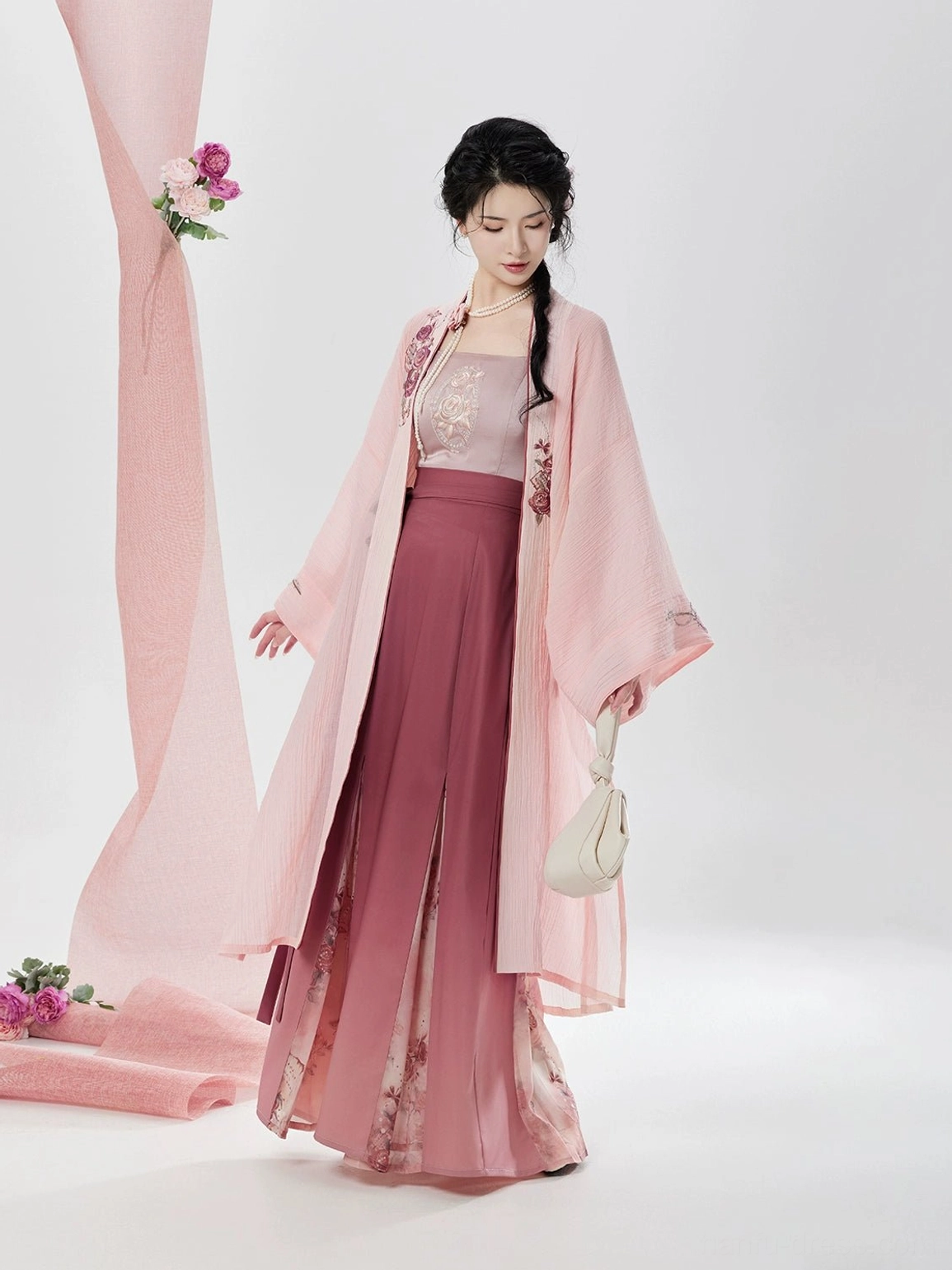 Rose Letter Song Dynasty modern hanfu three piece set shown from the front three quarter view with embroidered pink beizi jacket camisole and floral pleated wrap skirt