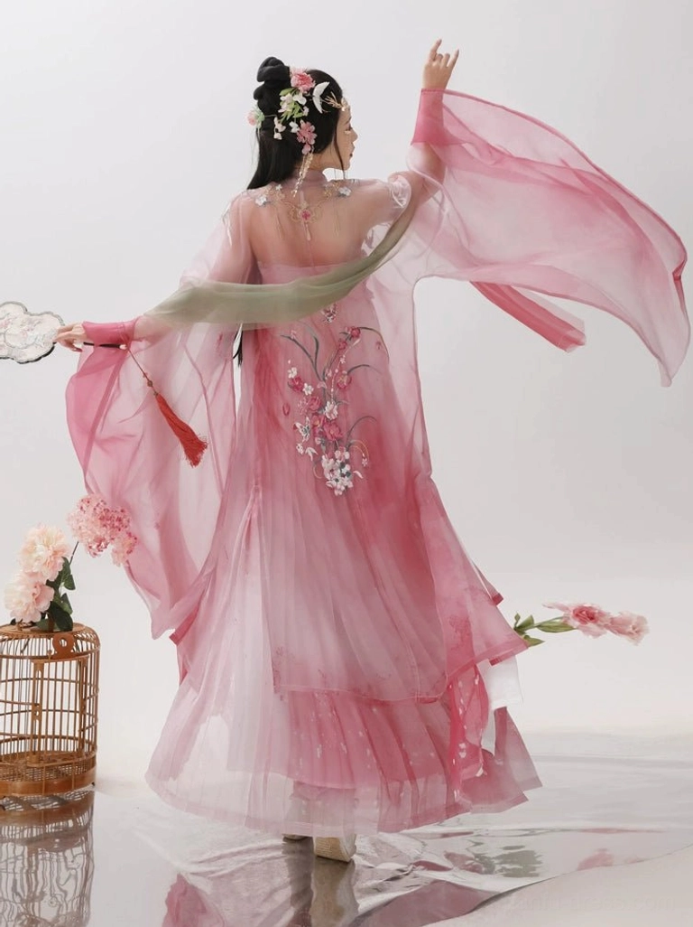 Back view of a rose pink Tang Dynasty Hanfu outfit with floral embroidery on the sheer wide-sleeved coat, flowing chiffon-like fabric, and green shoulder ribbon