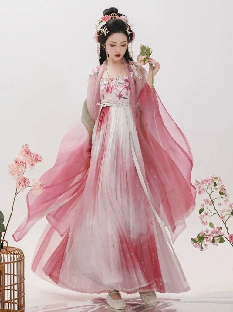 Front full-body view of a rose pink Tang Dynasty Hanfu Heziqun dress with ombre pink to white skirt, floral embroidered bust, sheer wide sleeves, and traditional flower hair ornaments