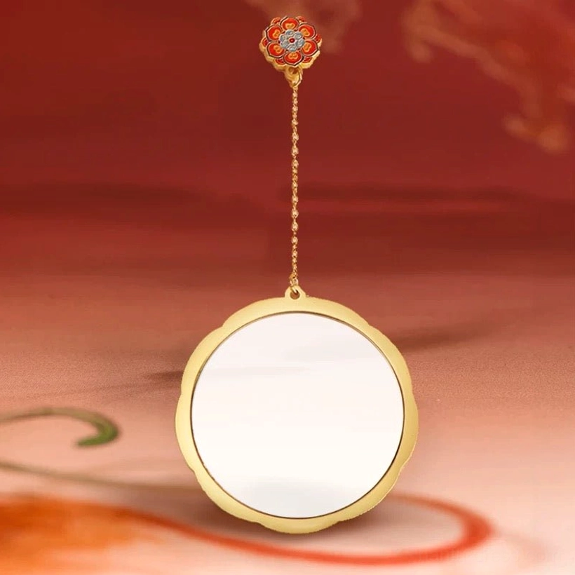 Round Chinese hand mirror with clear glass surface, polished scalloped gold frame, red turquoise and ivory enamel-style decoration, and flower-shaped hanging pendant