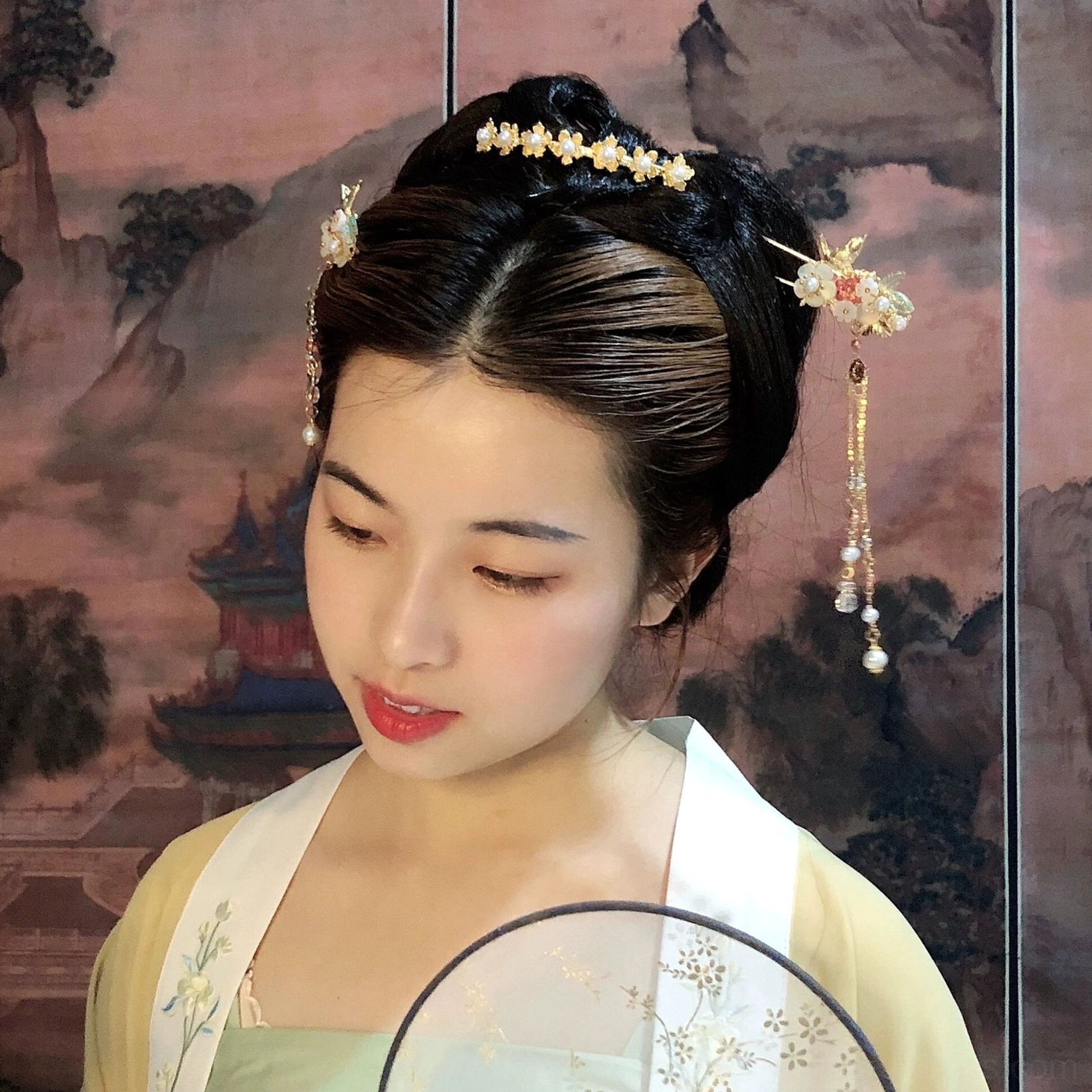 Model wearing Ruyao floral bird Hanfu hair accessory set with cascading tassels and front hair chain styled with yellow Hanfu and Chinese round fan