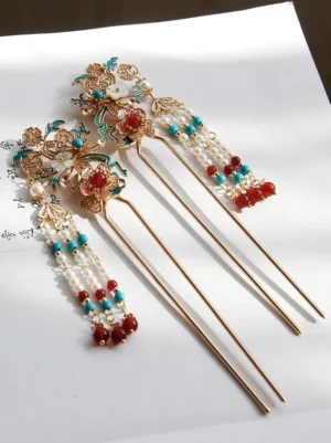 Matched Chinese hair stick and vintage tassel hairpin set with gold floral filigree blue enamel accents red bead details and imitation pearl tassels displayed on calligraphy paper