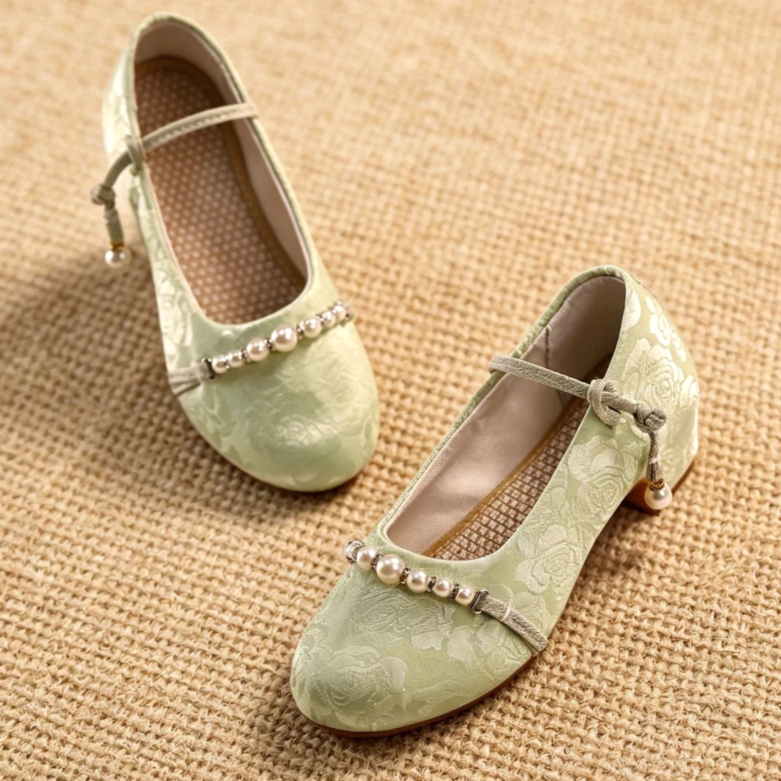 Separated view of sage green Chinese Hanfu Mary Jane shoes featuring adjustable bow ankle straps, pearl drop pendants, floral textured uppers, and block heels