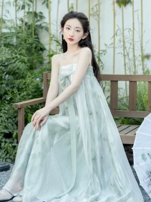 Front view of sage green modern Tang style Hanfu slip dress with bow knot neckline, flowing floor length skirt, and lightweight sheer outer coat