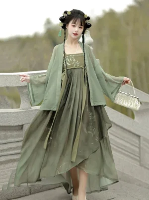 Sage green Qixiong Ruqun Hanfu dress with sheer cardigan and leaf embroidered bodice on a stone bridge