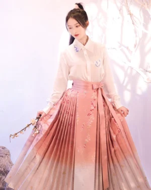 Front three-quarter view of Sakura Mamianqun horse face skirt with pink ivory gradient pleats floral motifs and front waist bow