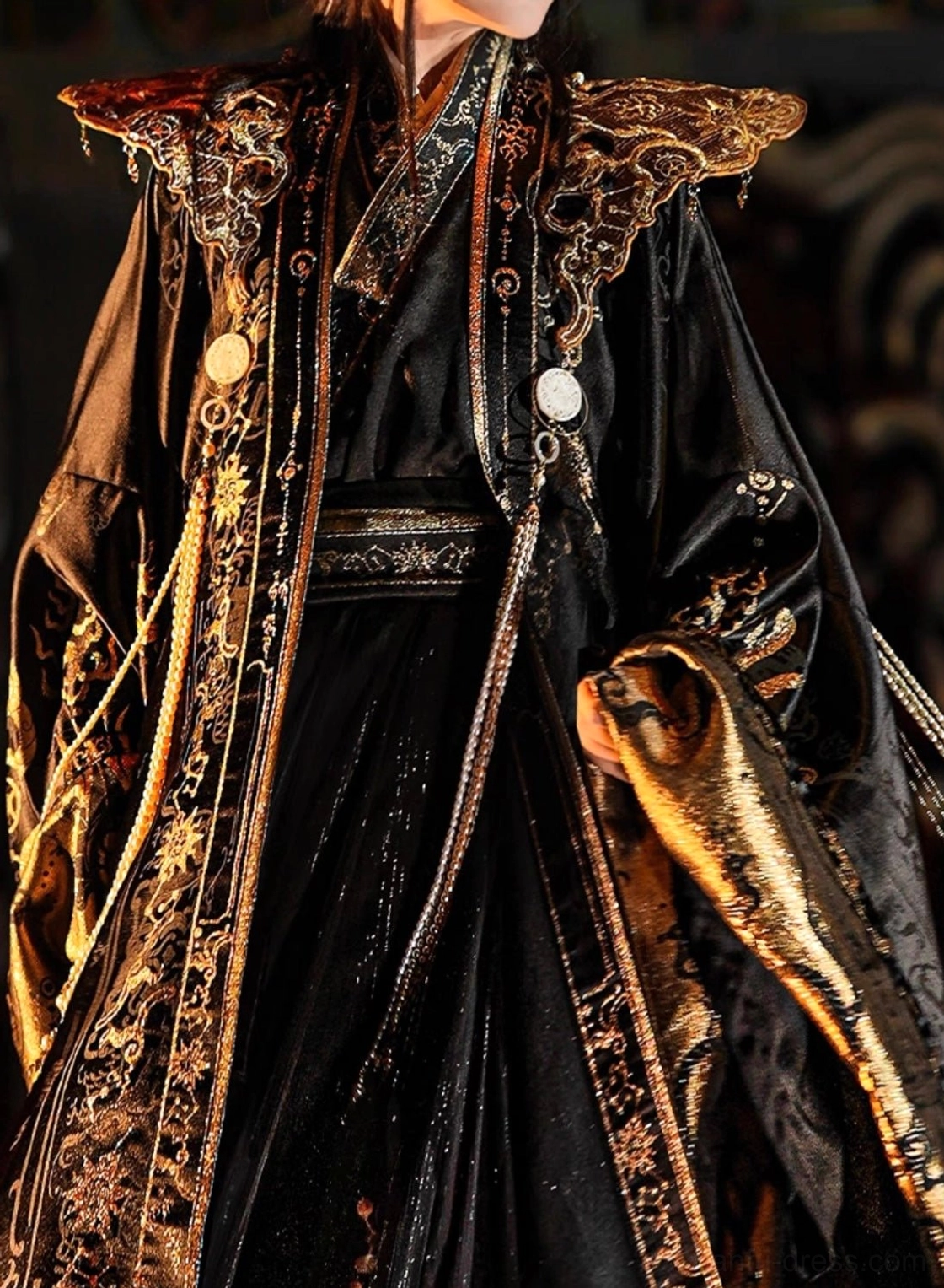 Close up detail of the Sanxingdui inspired xianxia hanfu upper body with carved golden shoulder pauldrons, cross collar neckline, gold trim, white jade style buttons, and ornate embroidery
