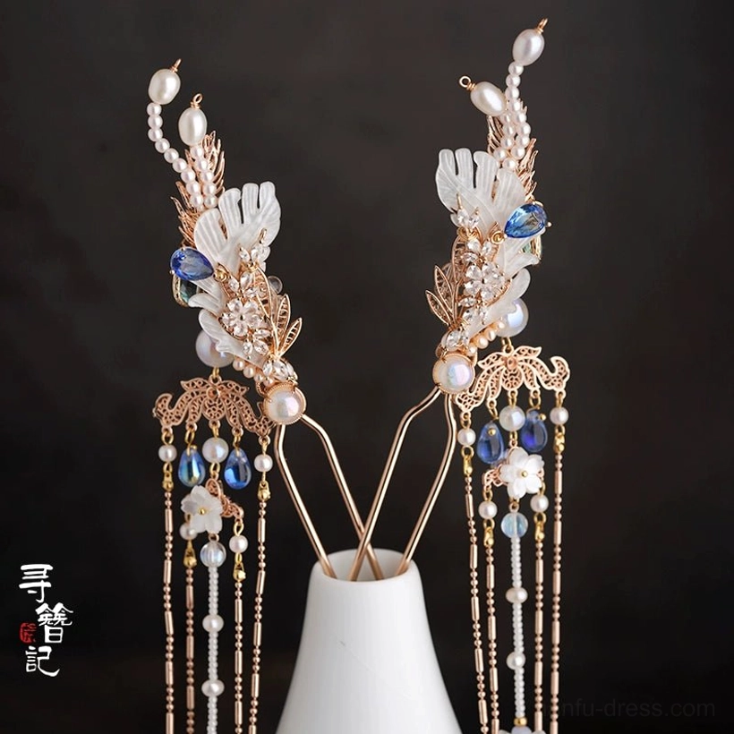 Pair of long sapphire blue crystal and white flower tassel hair pins for Hanfu displayed in a white ceramic vase
