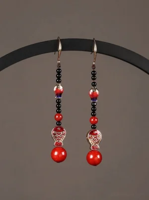 Scarlet koi fish Chinese earrings displayed on a black stand with red black and gold enamel details for cheongsam and Hanfu styling