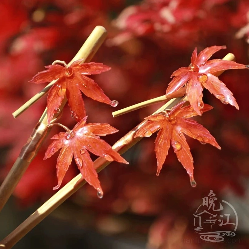 Scarlet maple leaf Chinese hair stick with resin dewdrop ornaments displayed among natural red maple leaves
