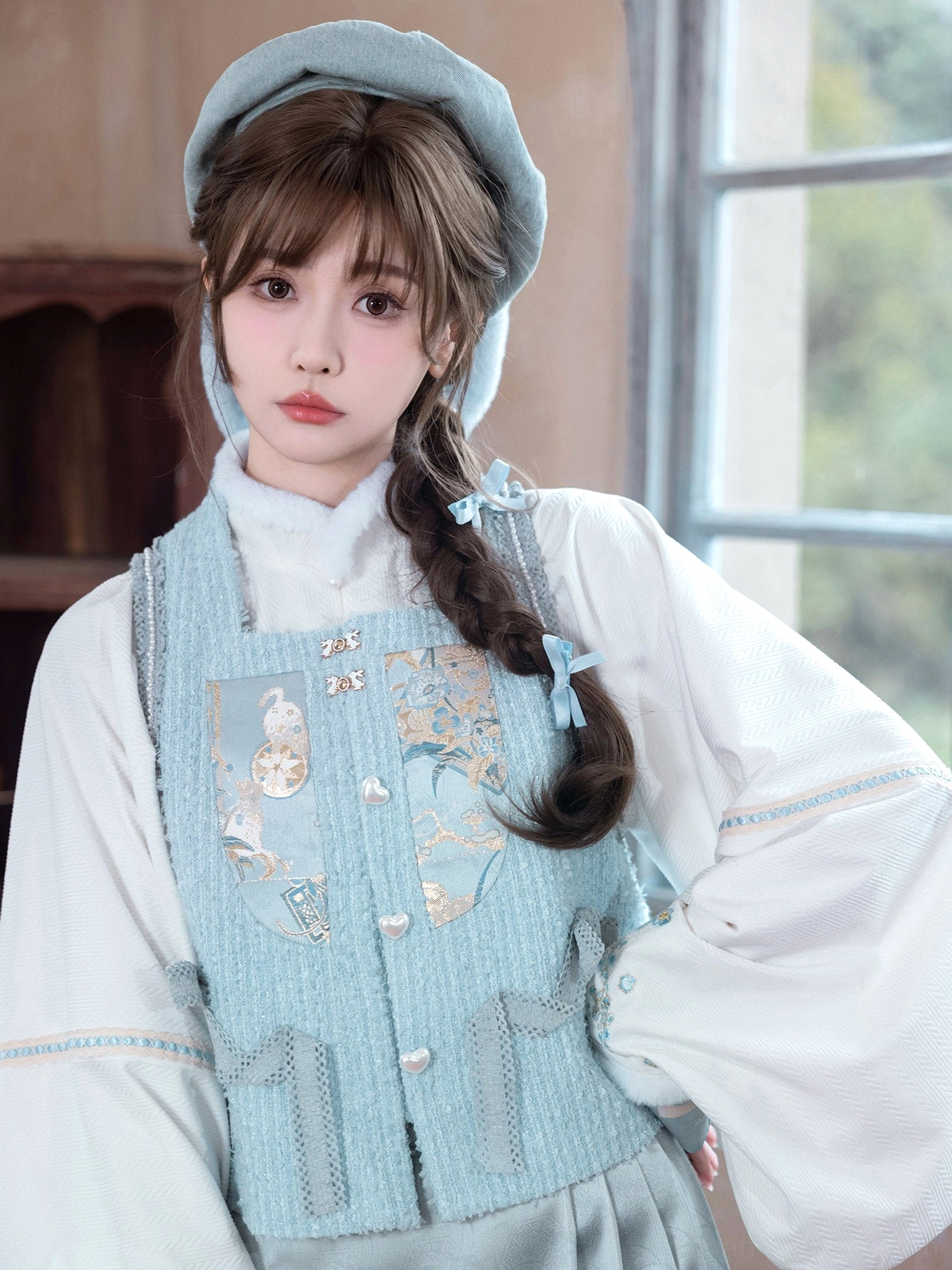 Close-up of floral embroidered Sea Salt Cream Hanfu bijia vest with pearl-style buttons and light cyan fabric