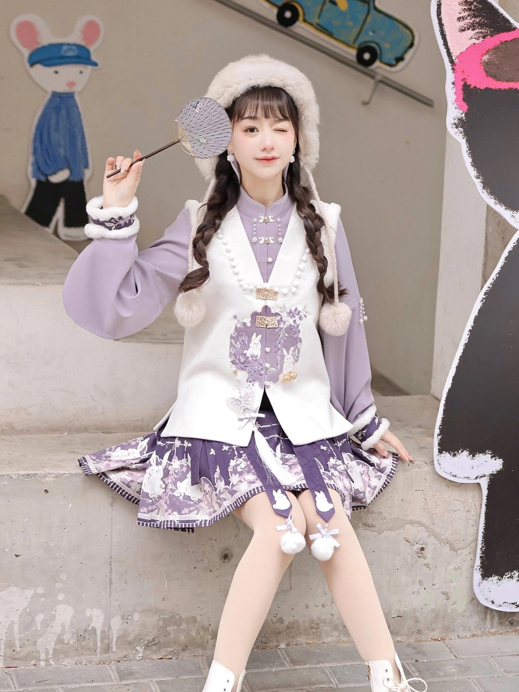 Seated model wearing a complete modern Chinese Hanfu outfit with embroidered rabbit vest, lavender pipa sleeve top, and decorated short horse face skirt