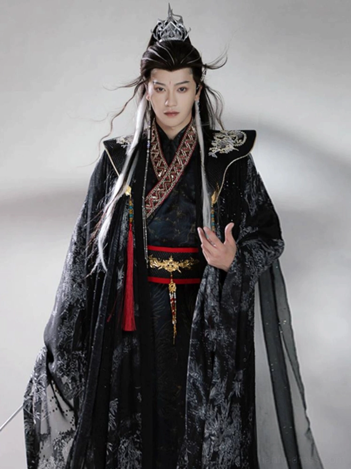 Side three-quarter view of Shadow Sovereign male Hanfu with flowing black printed cloak, red gold belt, and silver Chinese fantasy shoulder ornaments