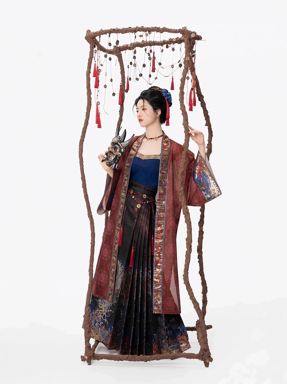 Three-quarter side view of the layered Shen Nuo Hanfu set showing the flowing overcoat, pleated brocade mamianqun skirt, and Nuo mask styling