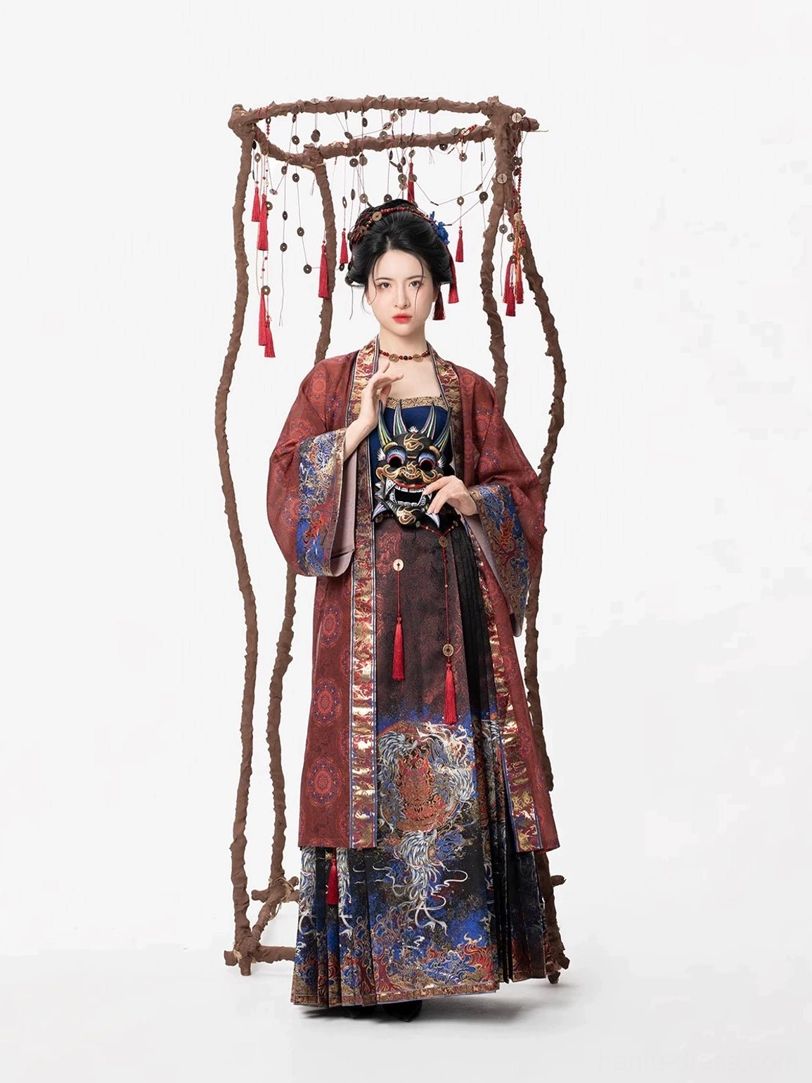 Front view of the Shen Nuo Ming Dynasty Hanfu outfit with reddish brown beizi overcoat, dark blue camisole, patterned mamianqun skirt, and red tassel accents