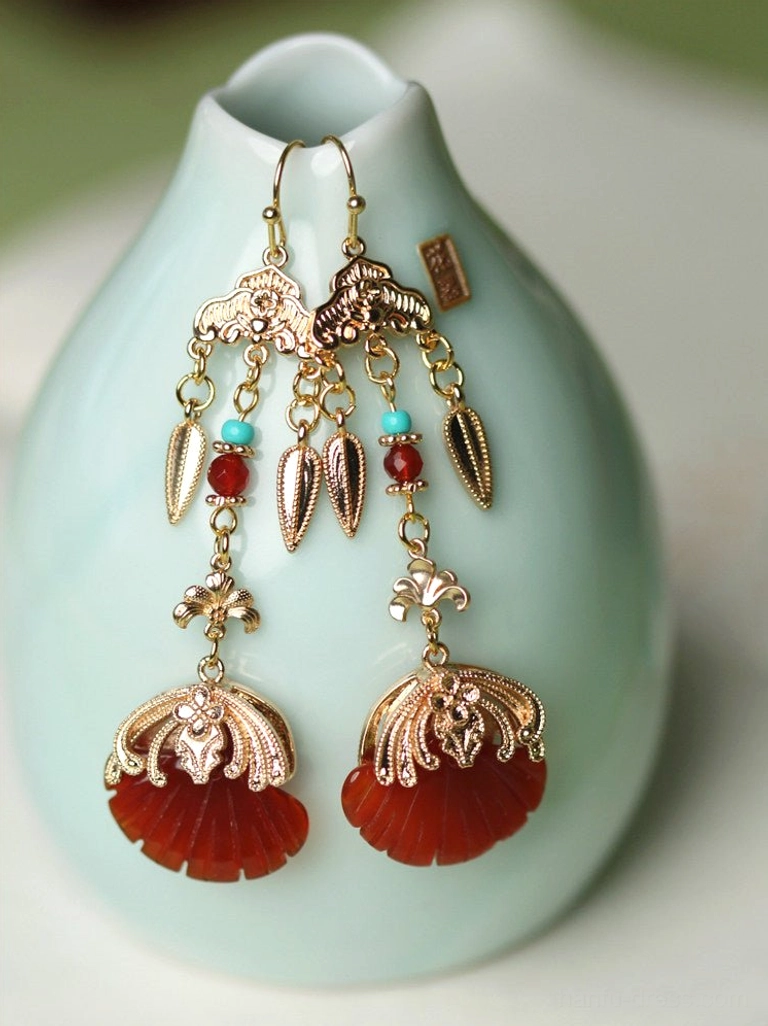Gold-toned Chinese Hanfu drop earrings displayed on a celadon ceramic vase with red fan pendants and colorful bead tassels