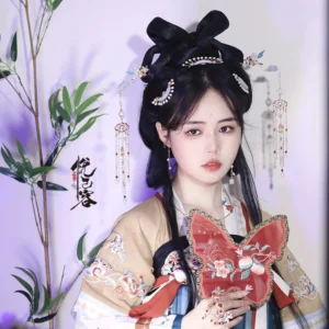 Model wearing a Tang-style Hanfu hairstyle with matching Chinese tassel hair pins and traditional hair accessories beside purple bamboo and Chinese calligraphy