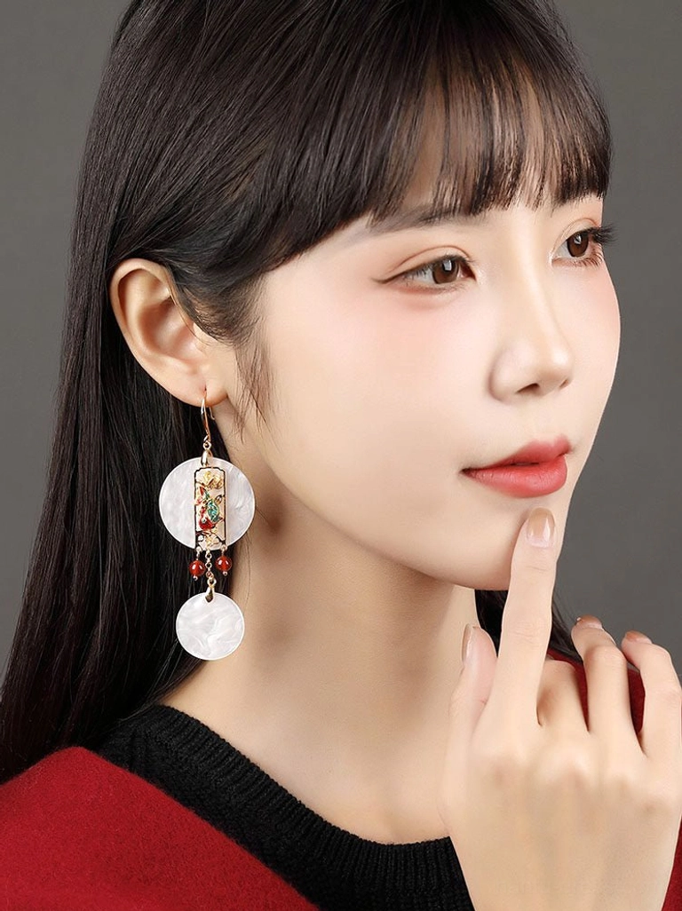 Side profile of a woman wearing graceful Chinese dangle earrings with white shell pendants and red decorative beads