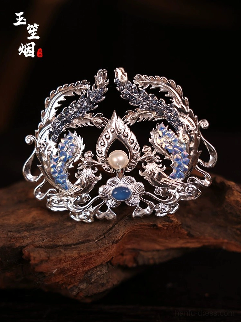 Silver double phoenix Hanfu hair crown ornament with blue enamel style details faux pearl and blue gemstone displayed on dark wood