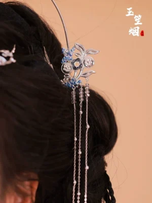 Back close-up of silver floral Hanfu tassel hairpin with blue enamel crystal details and long chain bead tassels in a traditional Chinese hairstyle