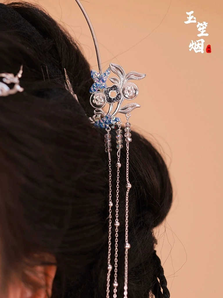 Back close-up of silver floral Hanfu tassel hairpin with blue enamel crystal details and long chain bead tassels in a traditional Chinese hairstyle