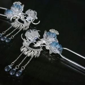 Pair of Silver Frost silver-tone Chinese hanfu hairpins with blue gradient flowers, bird-and-flower motifs, chain tassels, and blue teardrop beads on dark background