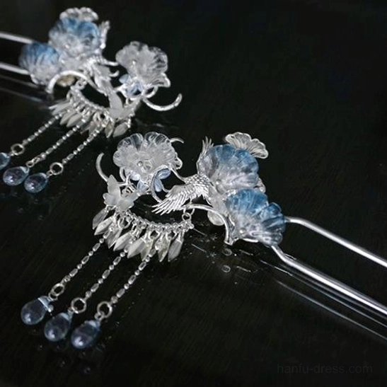 Pair of Silver Frost silver-tone Chinese hanfu hairpins with blue gradient flowers, bird-and-flower motifs, chain tassels, and blue teardrop beads on dark background