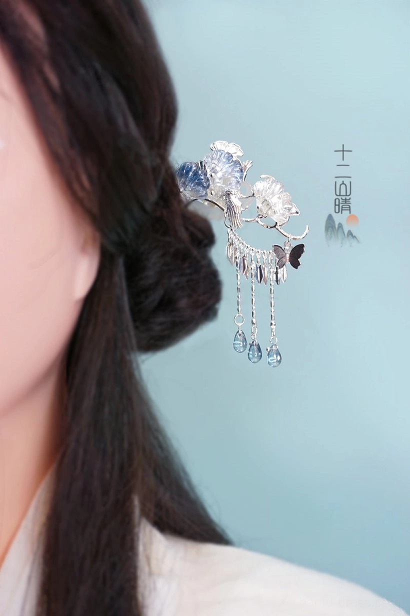 Back view of Silver Frost blue flower tassel Chinese hairpin styled in a traditional hanfu hairstyle with silver-tone chains and dangling blue glass pendants