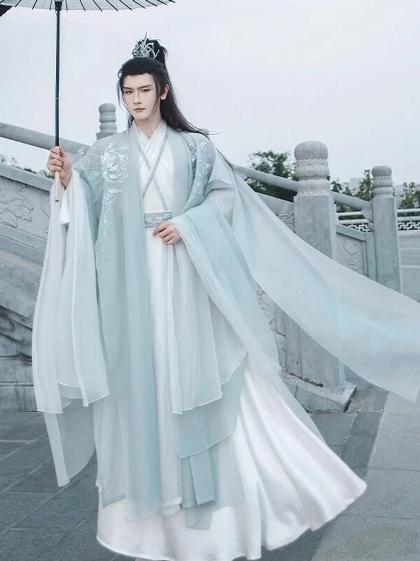 Full body front view of men's Wei Jin dynasty inspired cyan and white hanfu set with oversized sleeves and oil paper umbrella