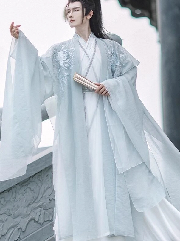 Men's pale cyan Wei Jin dynasty hanfu set with flowing wide sleeves embroidered shoulders and white inner layers holding a scroll
