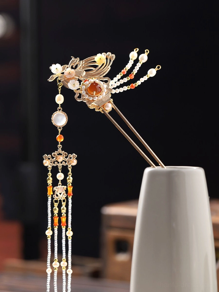 Front view of a single phoenix tassel Chinese hair stick with ornate gold bird motif red center stone and white bead chains