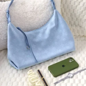 Sky blue Chinese-inspired crescent shoulder bag with floral embossing, light blue trims, metal hardware, and leather tassel styled with everyday accessories