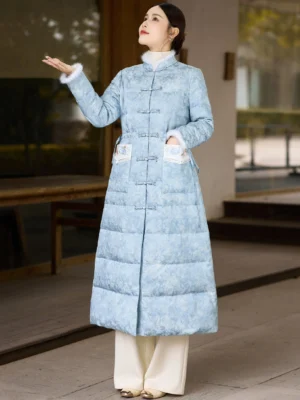 Three-quarter side view of women's sky blue Chinese style long down coat showing plush cuff trim quilted insulation and embroidered pocket details