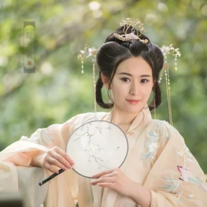 Model wearing a complete Sky Phoenix hanfu hair accessories set with crown and side hairpins, styled with an apricot embroidered hanfu and traditional Chinese hand fan