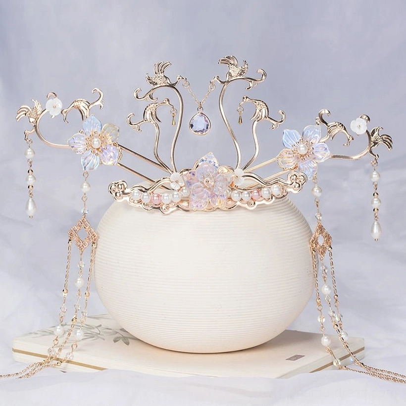 Sky Phoenix hanfu hair crown featuring ornate gold toned vines, blue purple glass flowers, pearl drops, and flowing tassels displayed on a ceramic vase