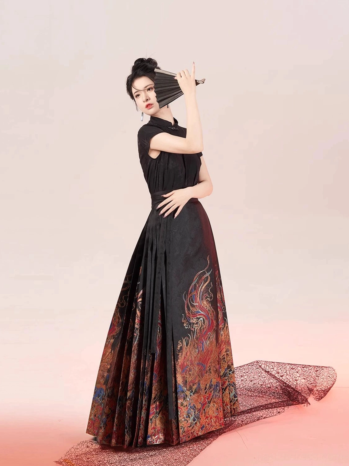 Sleeveless black Chinese style hanfu blouse paired with an ornate pleated mamian skirt and folding fan