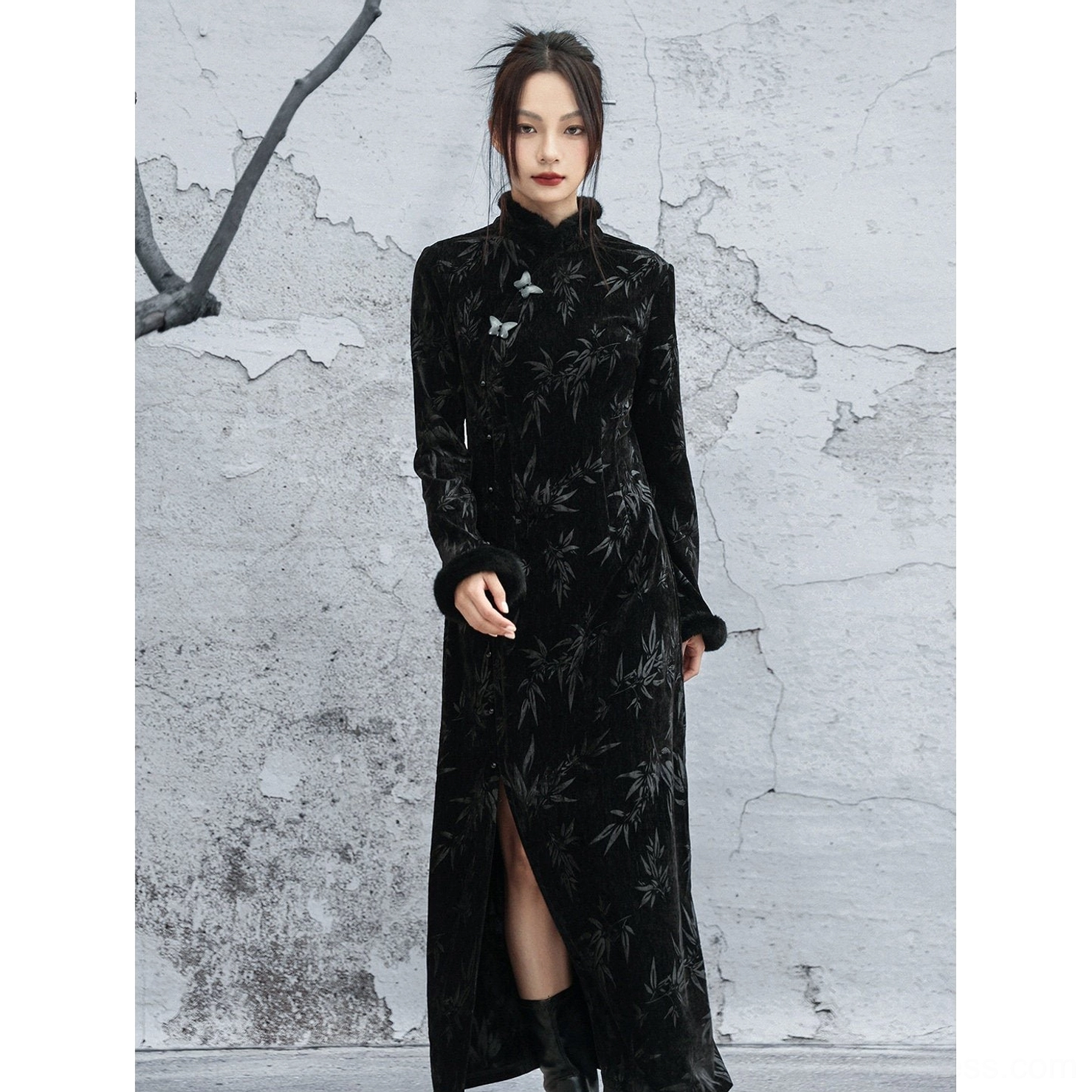 Distant full-body view of slim-fit black bamboo jacquard cheongsam modern Hanfu dress with high side slit, fur-trimmed cuffs, and black ankle boots